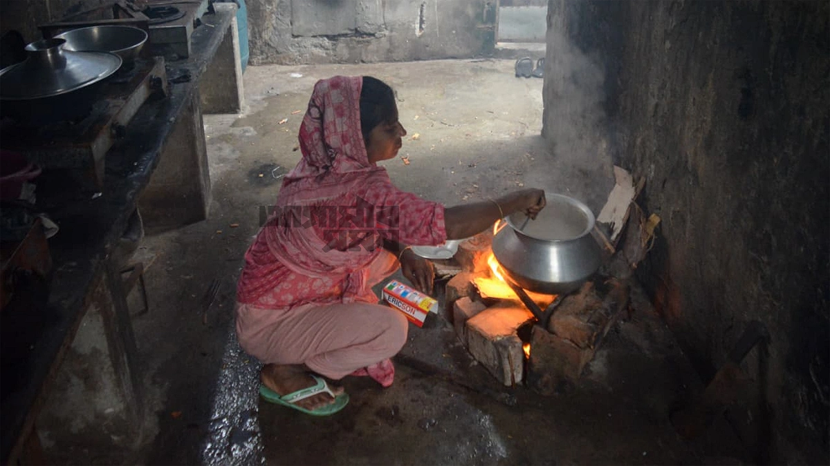 নবোদয় হাউজিংয়ে মাটির চুলায় রান্না করছেন এক নারী। ছবি আশিকুর রহমান