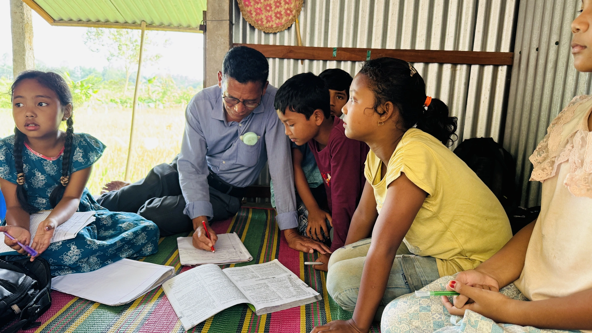 শিক্ষার্থী পরিবেষ্টিত হয়ে আছেন প্রদীপ ম্রং।